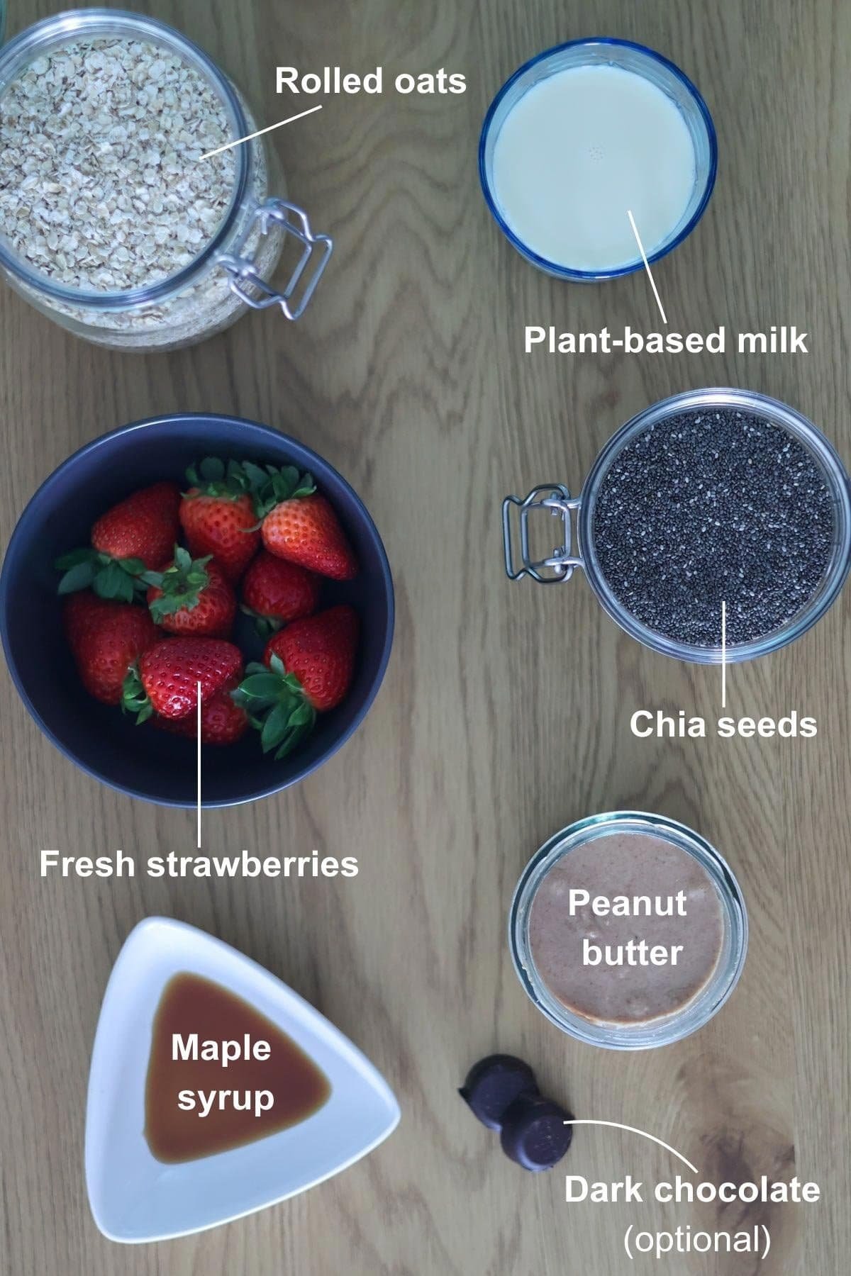 All the ingredients for the peanut butter and jelly overnight oats on a wooden table.