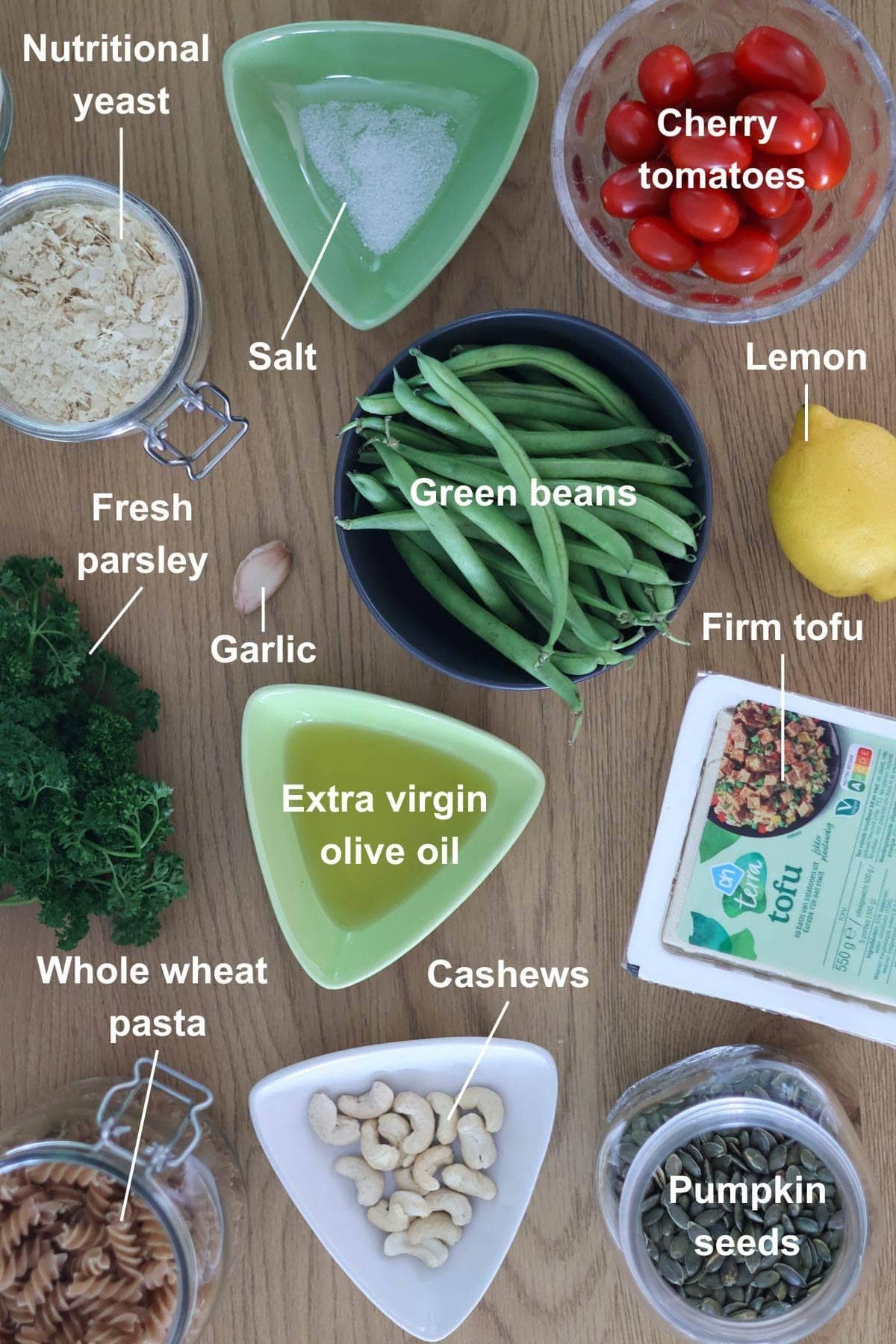 All the ingredients for the vegan pasta pesto recipe on a wooden table.