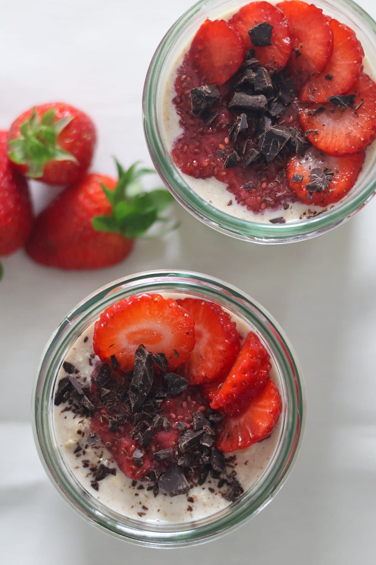 Two glass jars filled with peanut butter and jelly overnight oats.