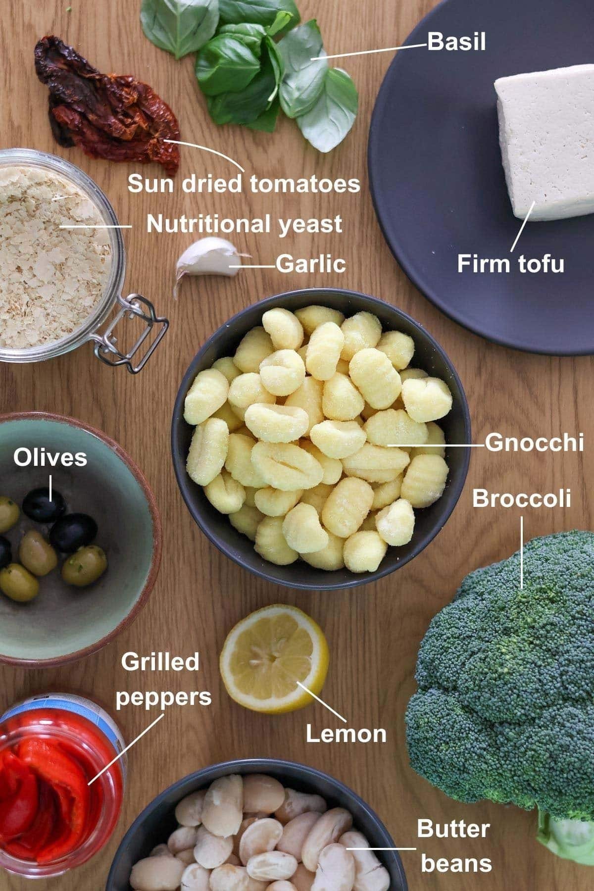 All of the ingredients for the Easy Oven-Baked Vegan Gnocchi recipe on a wooden table.