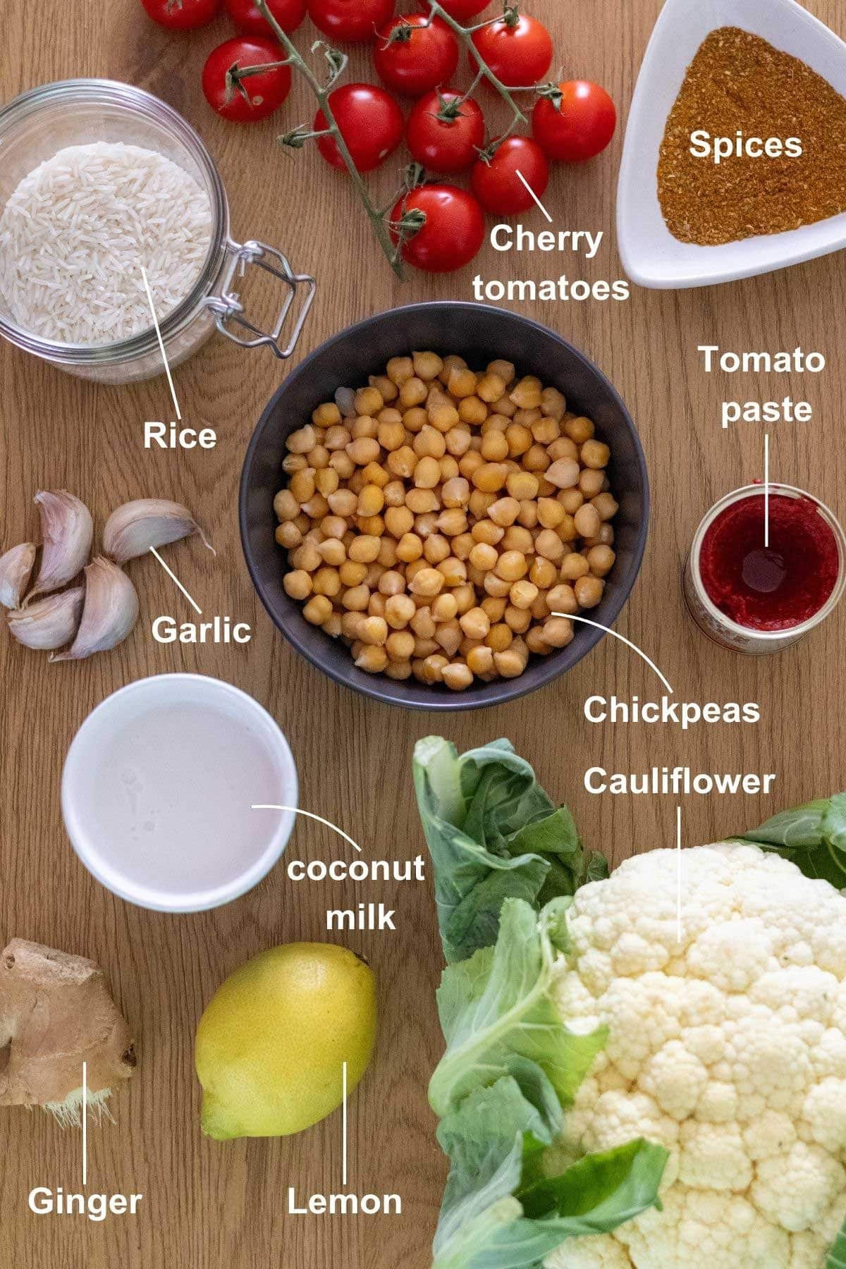 The ingredients for the cauliflower and chickpea curry with rice on a wooden table.