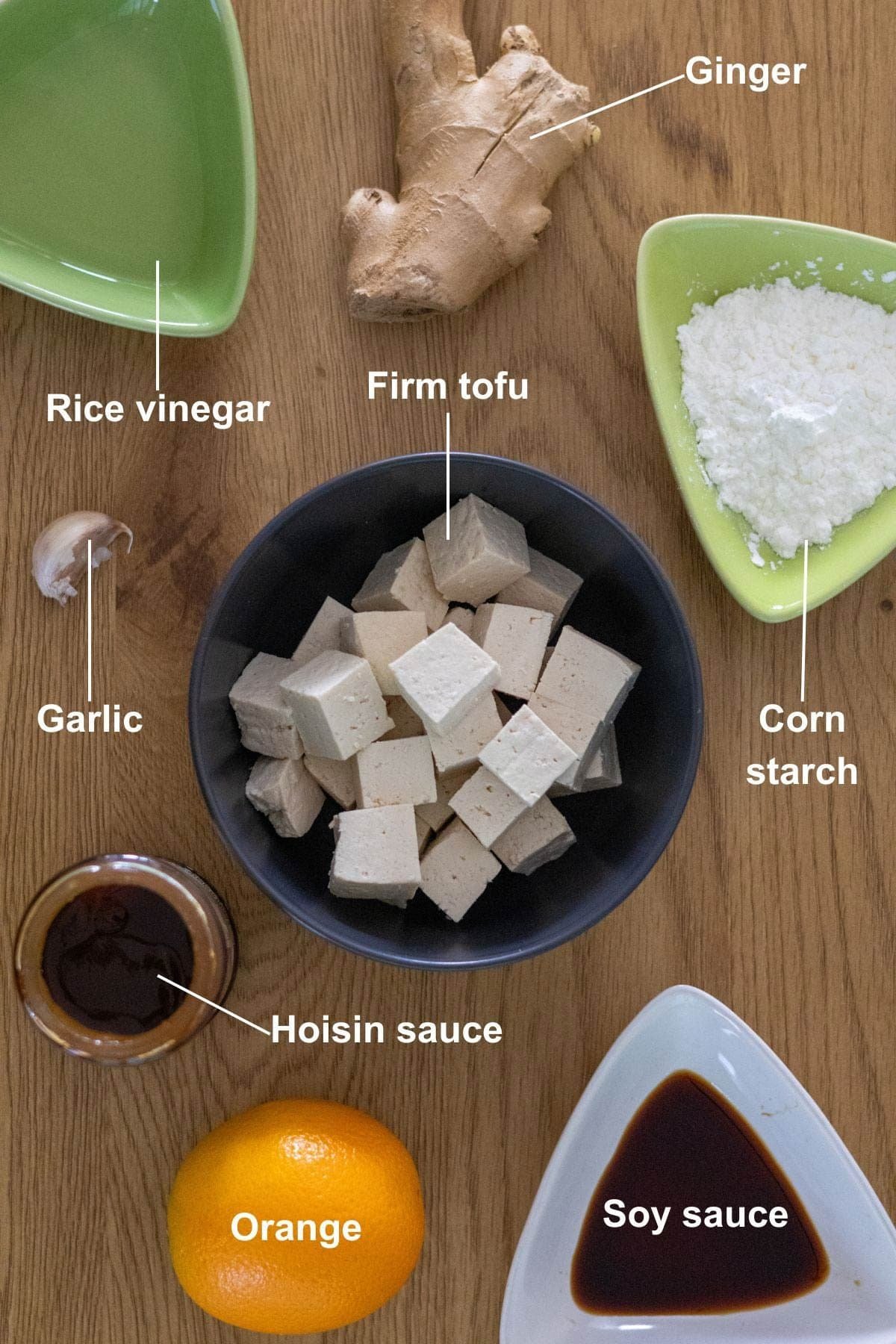 The ingredients for the orange tofu recipe on a wooden table.