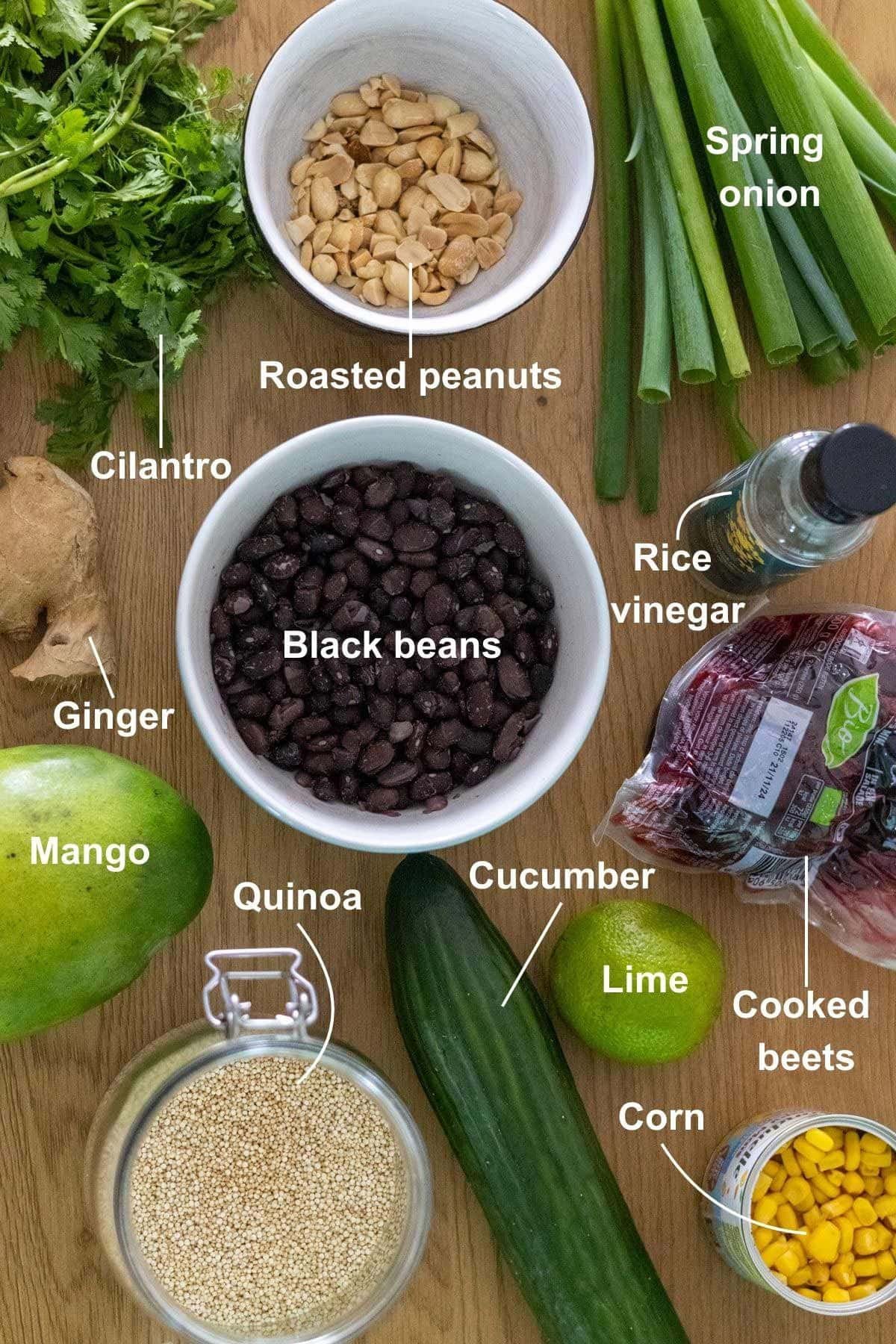 All the ingredients for the Quinoa Black Bean and Mango Salad on a wooden table.