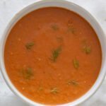 A small white bowl filled with Tomato and Fennel Soup.