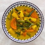 Vegan Thai Yellow Curry with green beans, carrot, baby corn and chickpeas in a blue and white bowl.