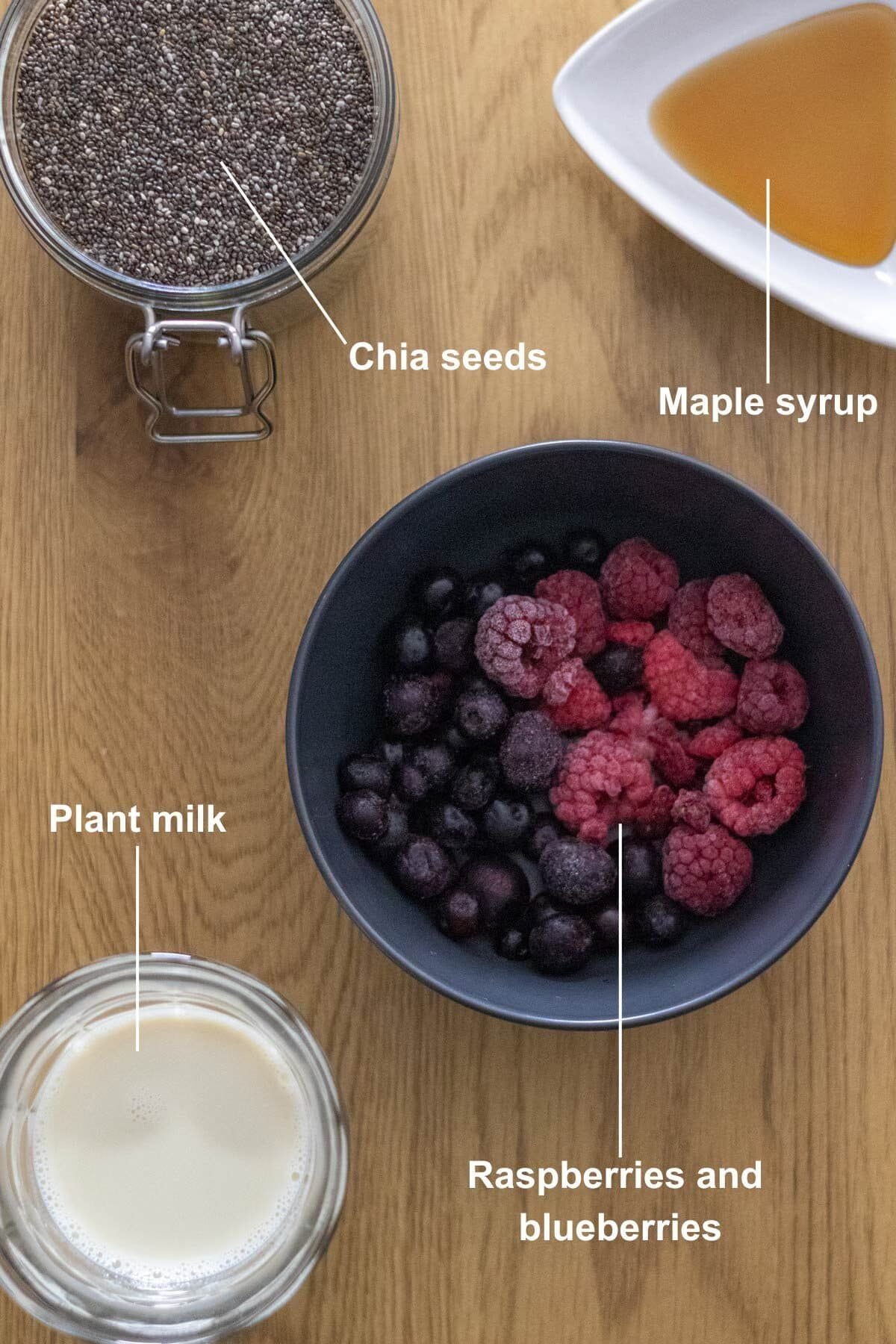 All the ingredients for the Berry Chia Pudding on a wooden table.