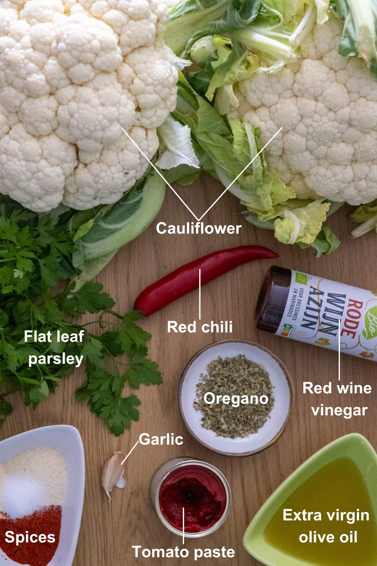 The ingredients for the Vegan Cauliflower Steak With chimichurri on a wooden table.